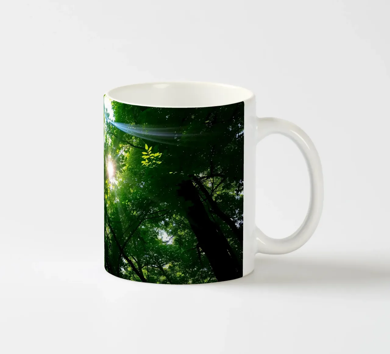 Sunlight filtering through dense green trees in calm ceramic mug by DesignDoodle