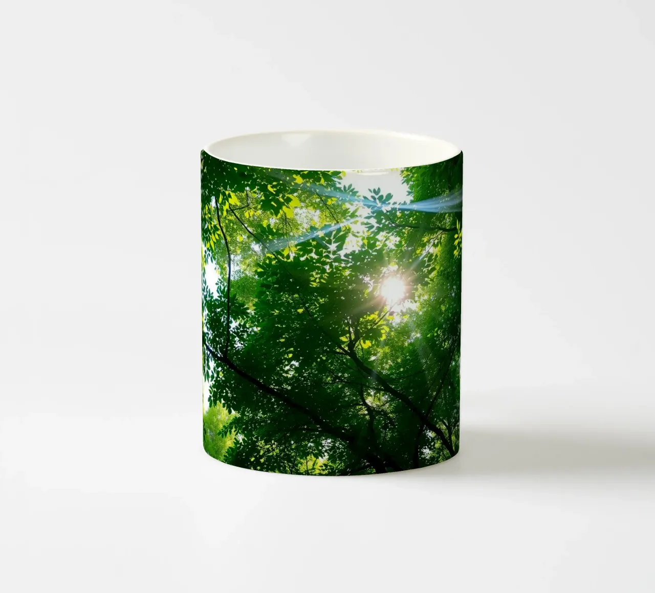 Sunlight filtering through dense green trees in calm ceramic mug by DesignDoodle