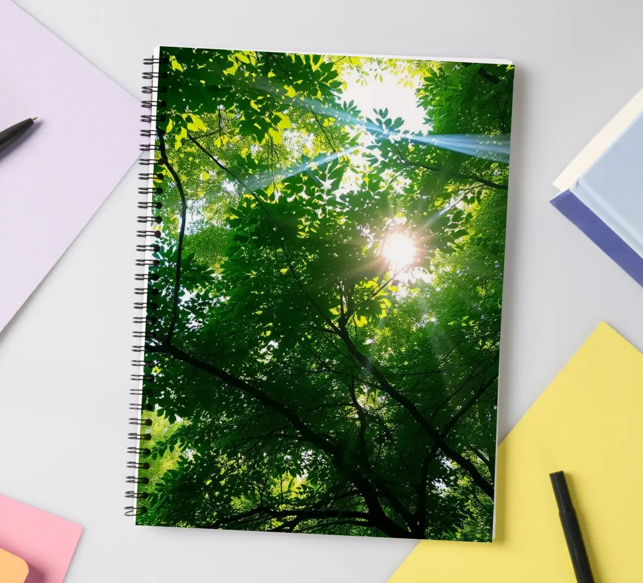 Lumière du soleil filtrant à travers des arbres denses et verts dans le calme carnet à spirale de DesignDoodle