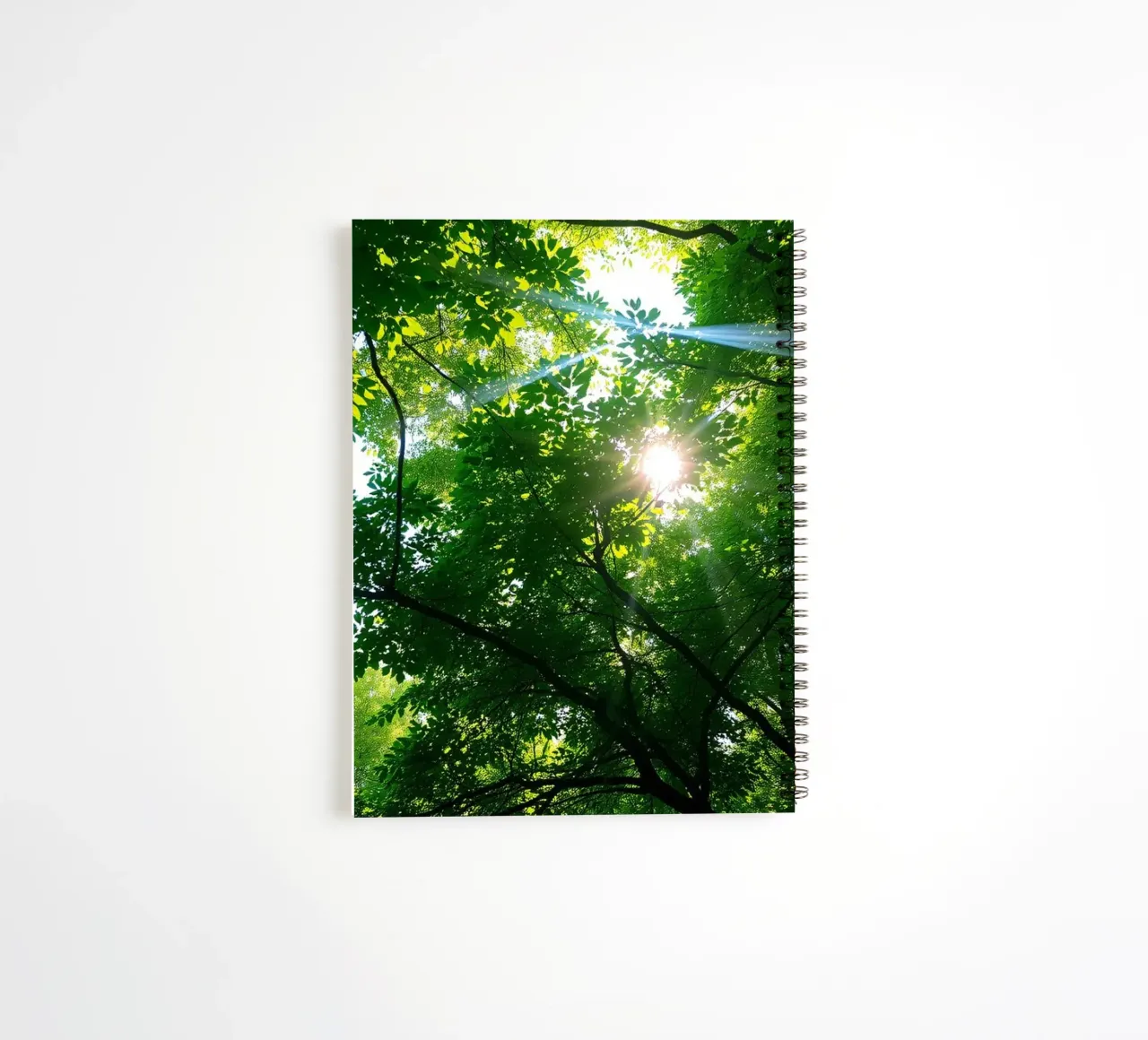 Sunlight filtering through dense green trees in calm spiral notebook by DesignDoodle