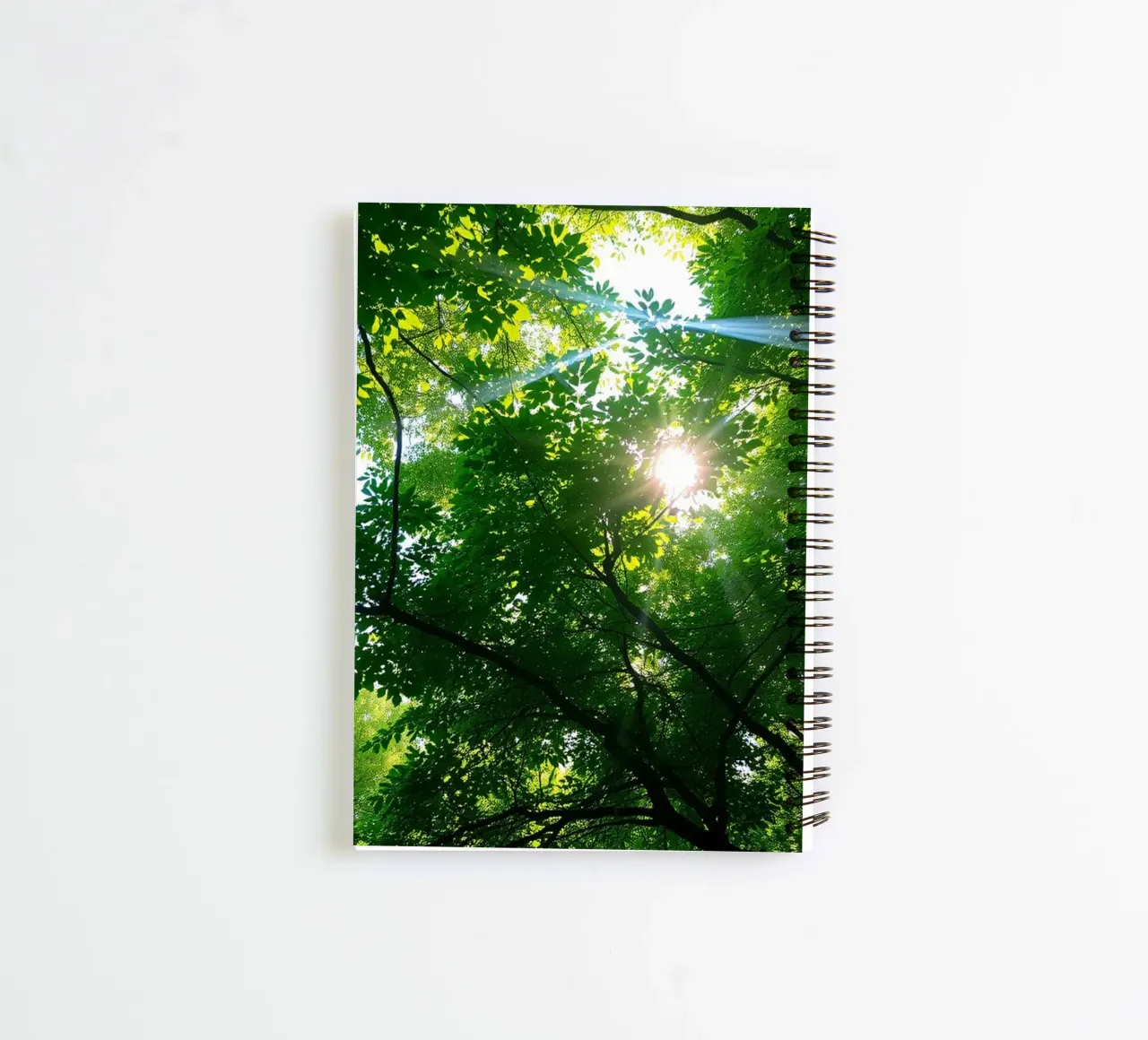 Sunlight filtering through dense green trees in calm spiral notebook by DesignDoodle