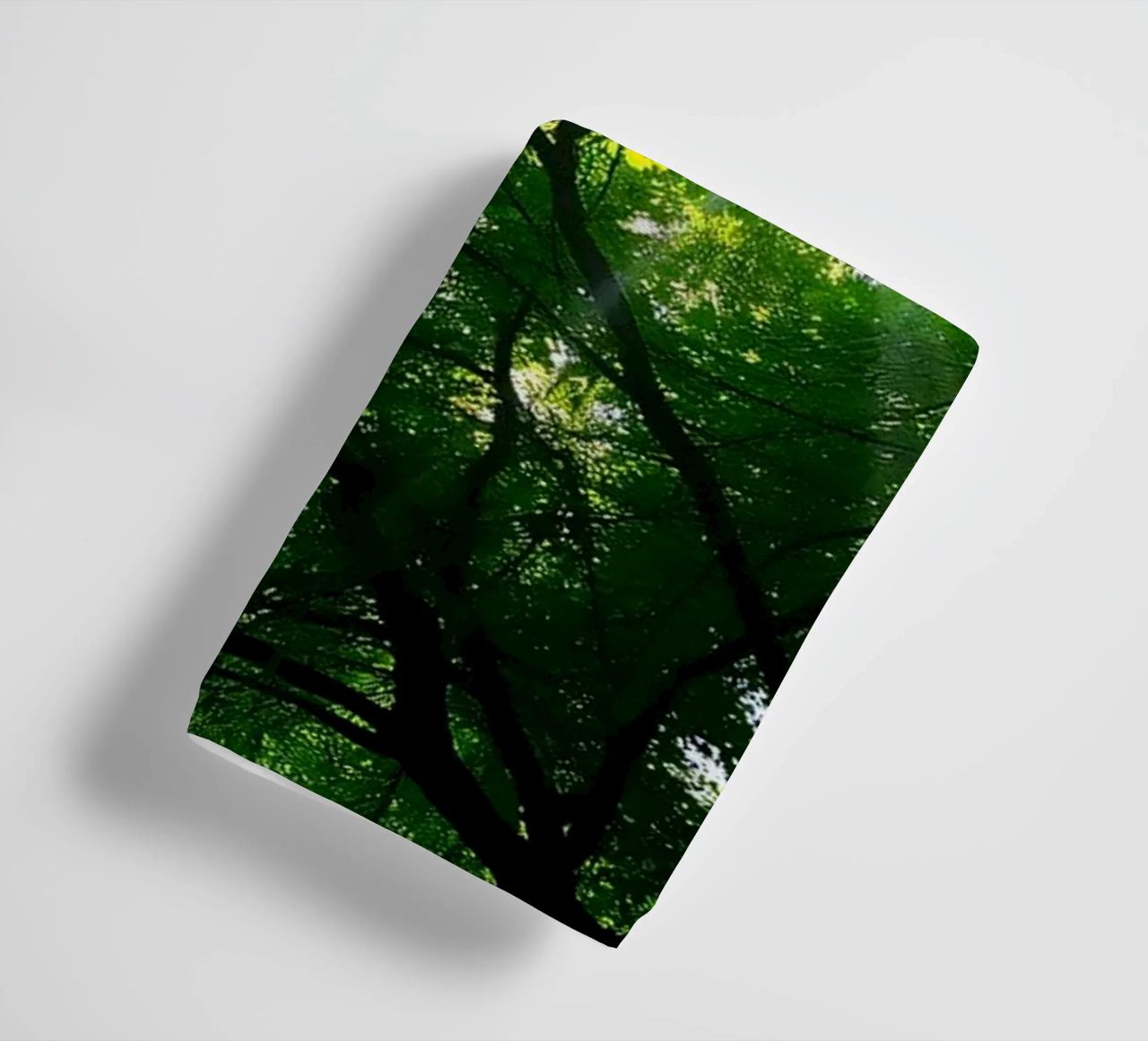 Sunlight filtering through dense green trees in calm towel by DesignDoodle