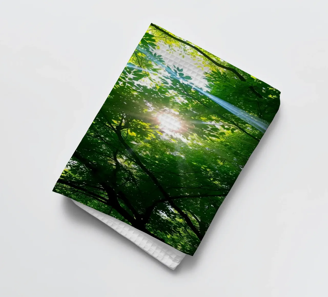 Lumière du soleil filtrant à travers des arbres denses et verts dans le calme torchon de DesignDoodle