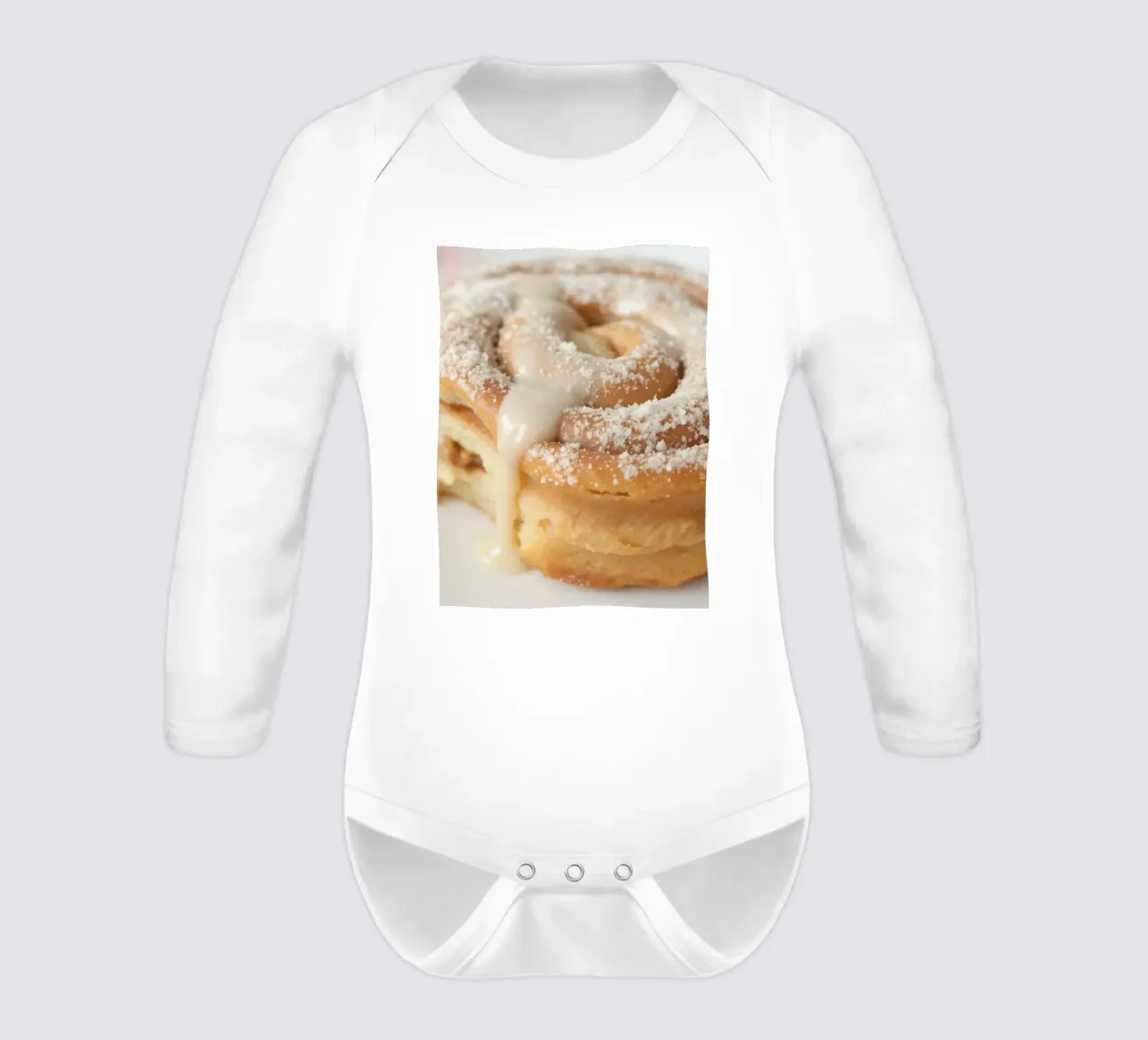 Warm cinnamon roll with cream icing and powdered sugar on a long-sleeve baby romper by DesignDoodle