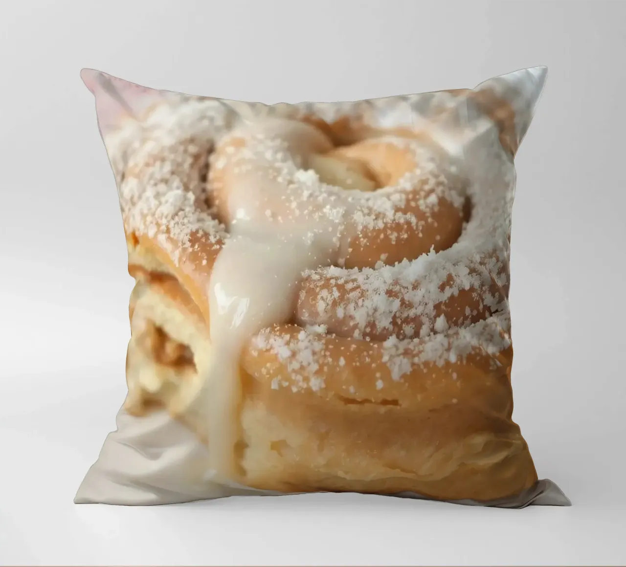 Warm cinnamon roll with cream icing and powdered sugar on a decorative cushion by DesignDoodle