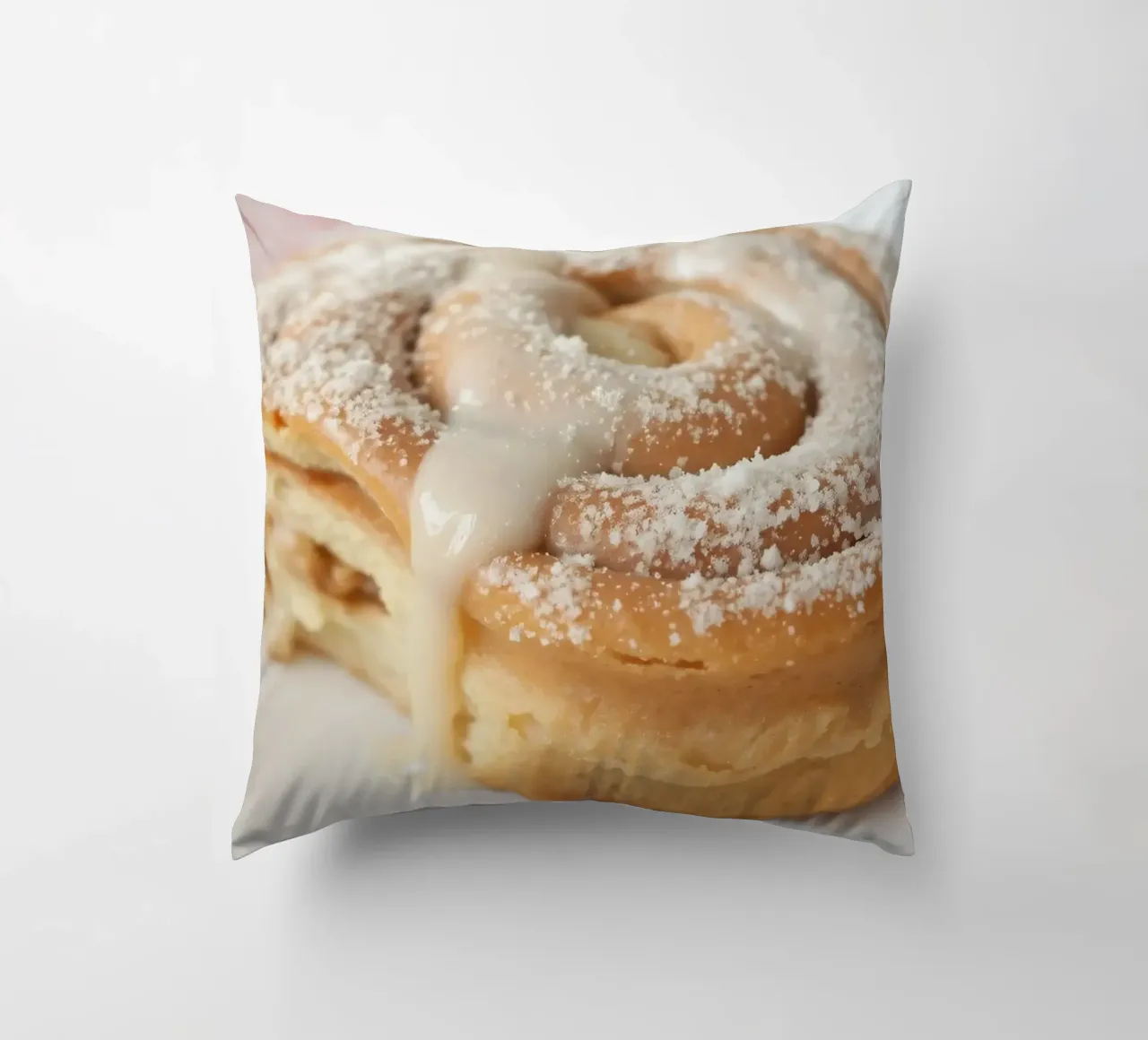 Warm cinnamon roll with cream icing and powdered sugar on a decorative cushion by DesignDoodle