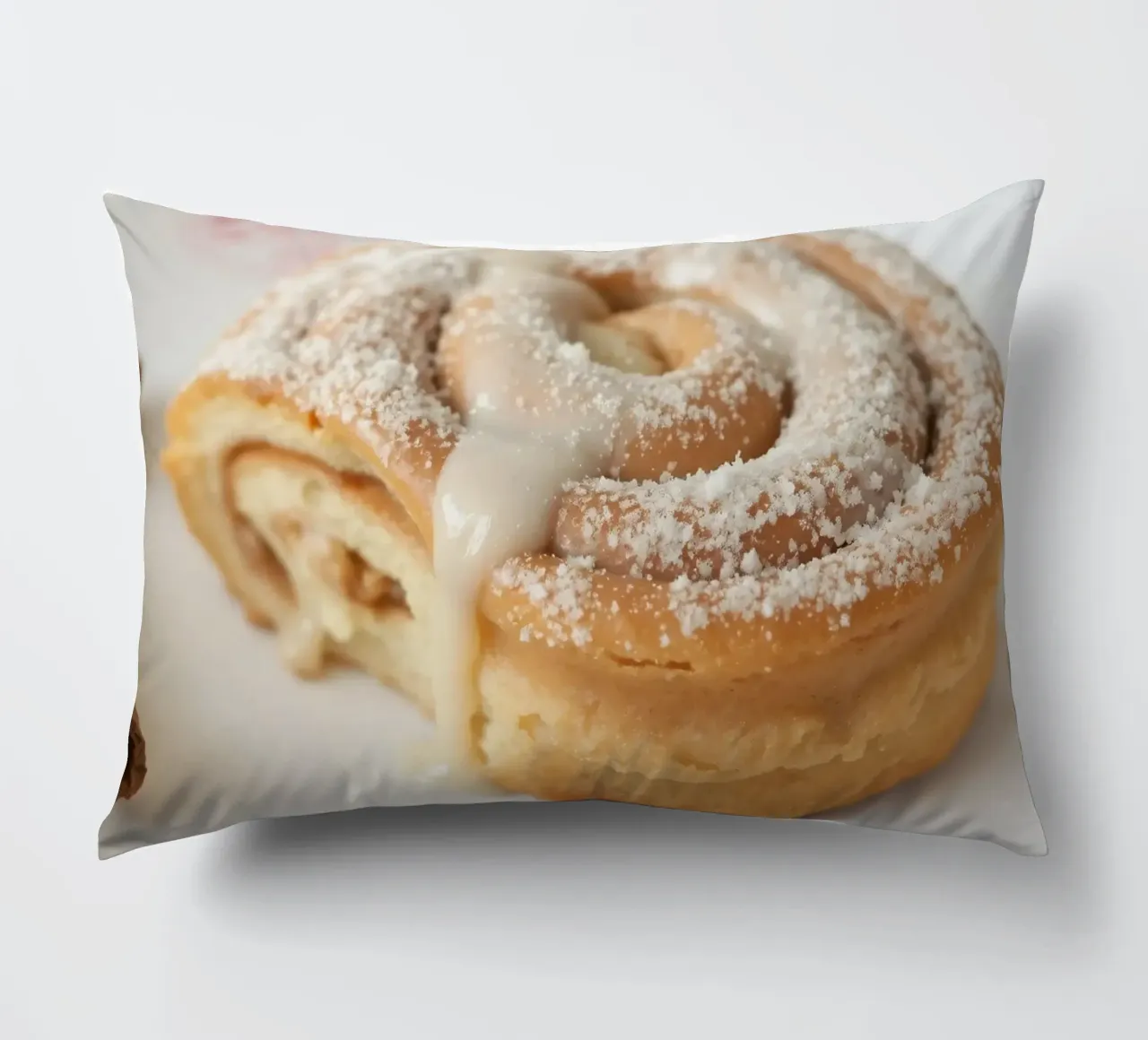 Warm cinnamon roll with cream icing and powdered sugar on a decorative cushion by DesignDoodle