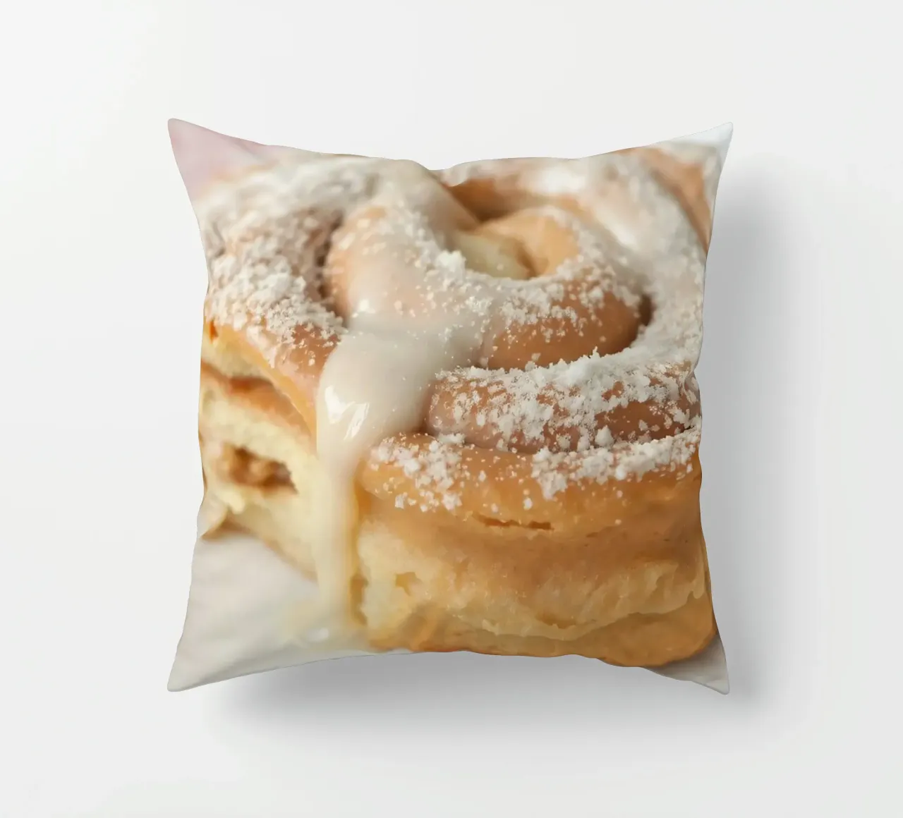 Warm cinnamon roll with cream icing and powdered sugar on a decorative cushion by DesignDoodle