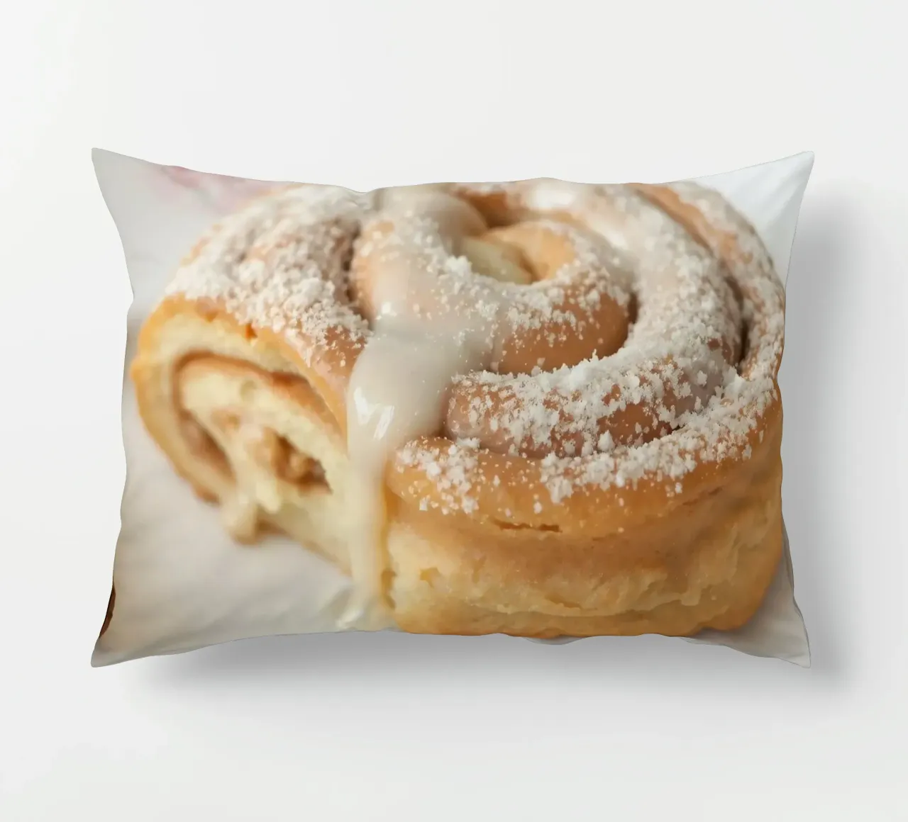 Warm cinnamon roll with cream icing and powdered sugar on a decorative cushion by DesignDoodle