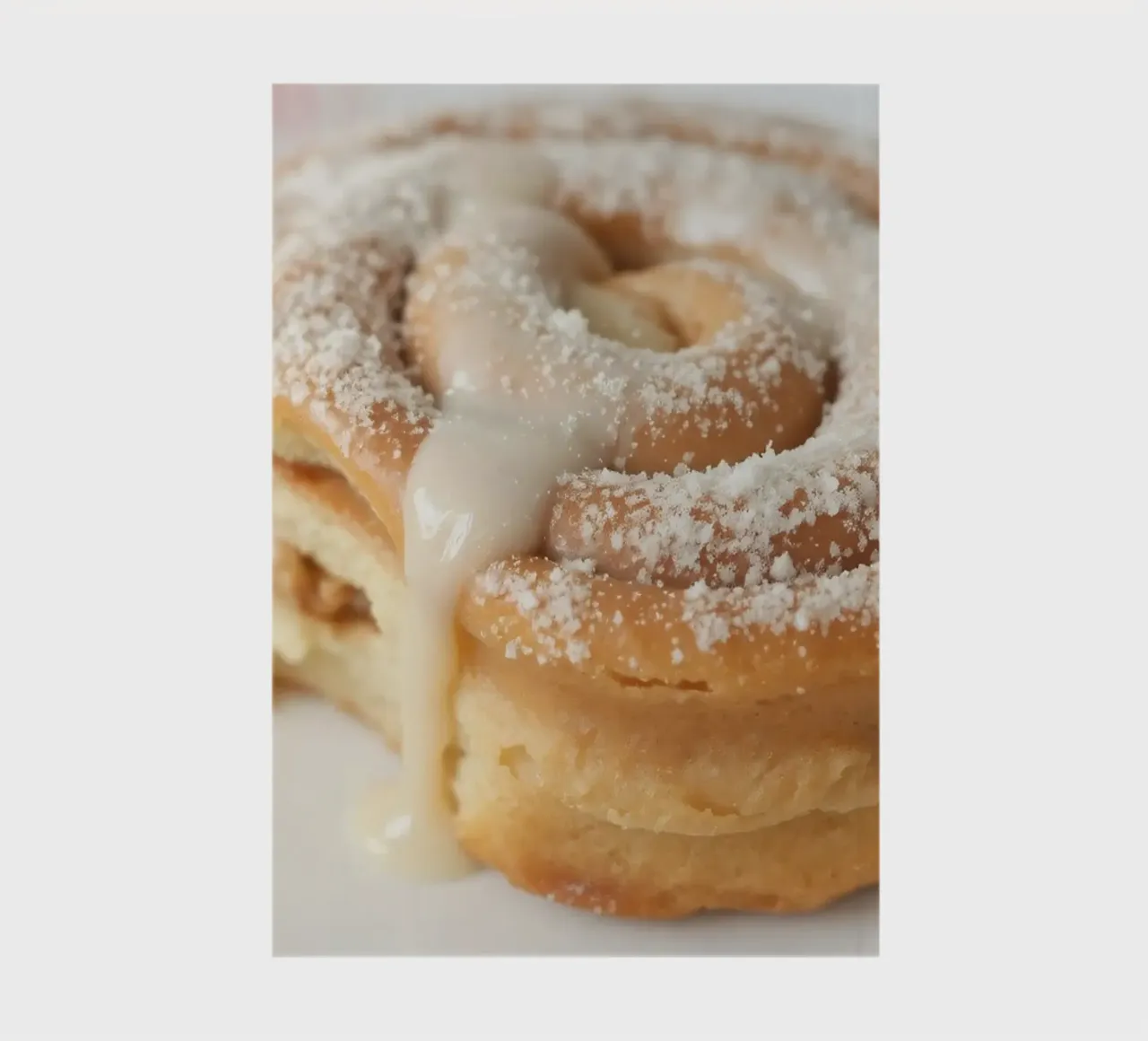 Warm cinnamon roll with cream icing and powdered sugar on a notebook by DesignDoodle