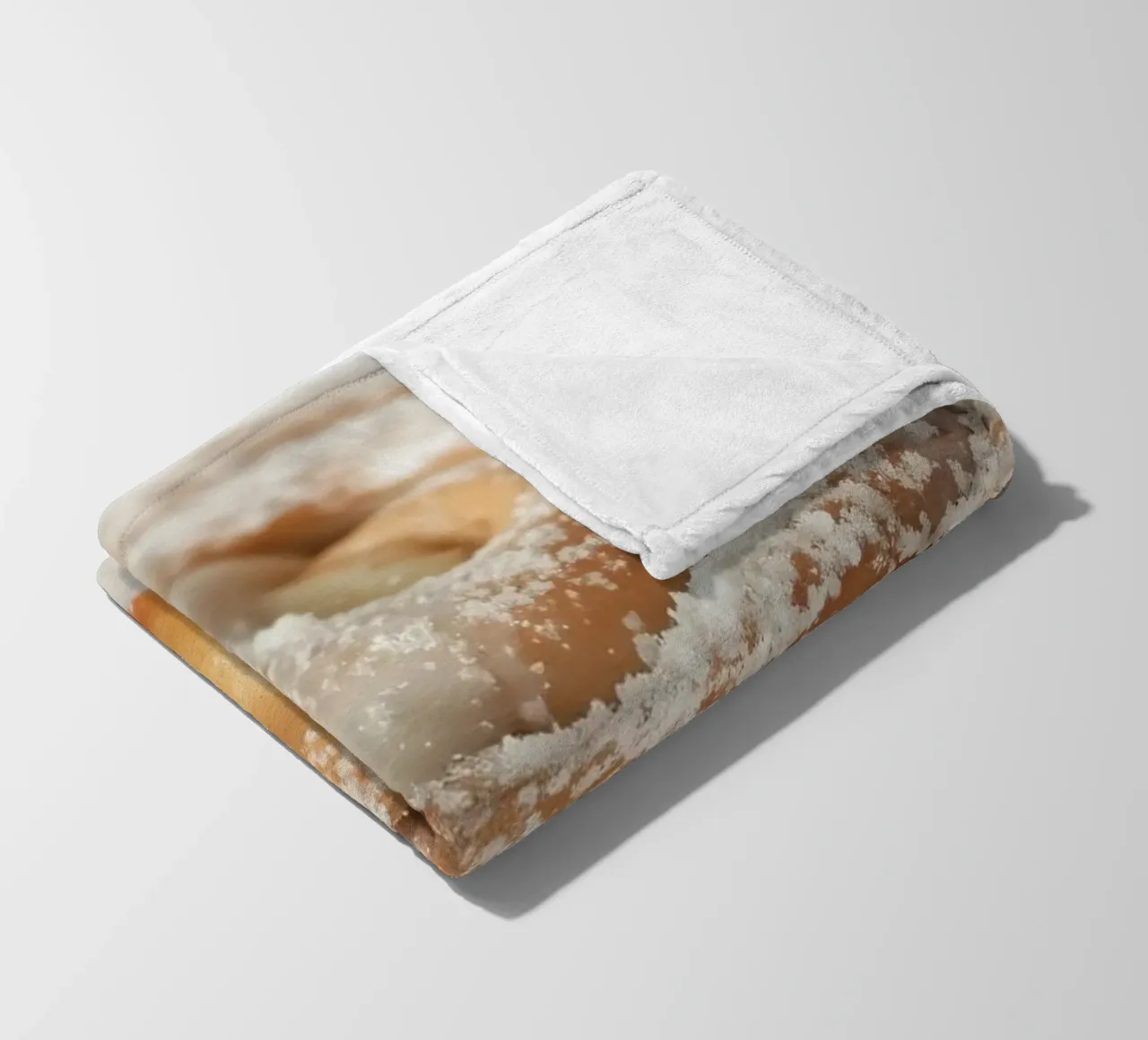 Warm cinnamon roll with cream icing and powdered sugar on a fleece blanket by DesignDoodle