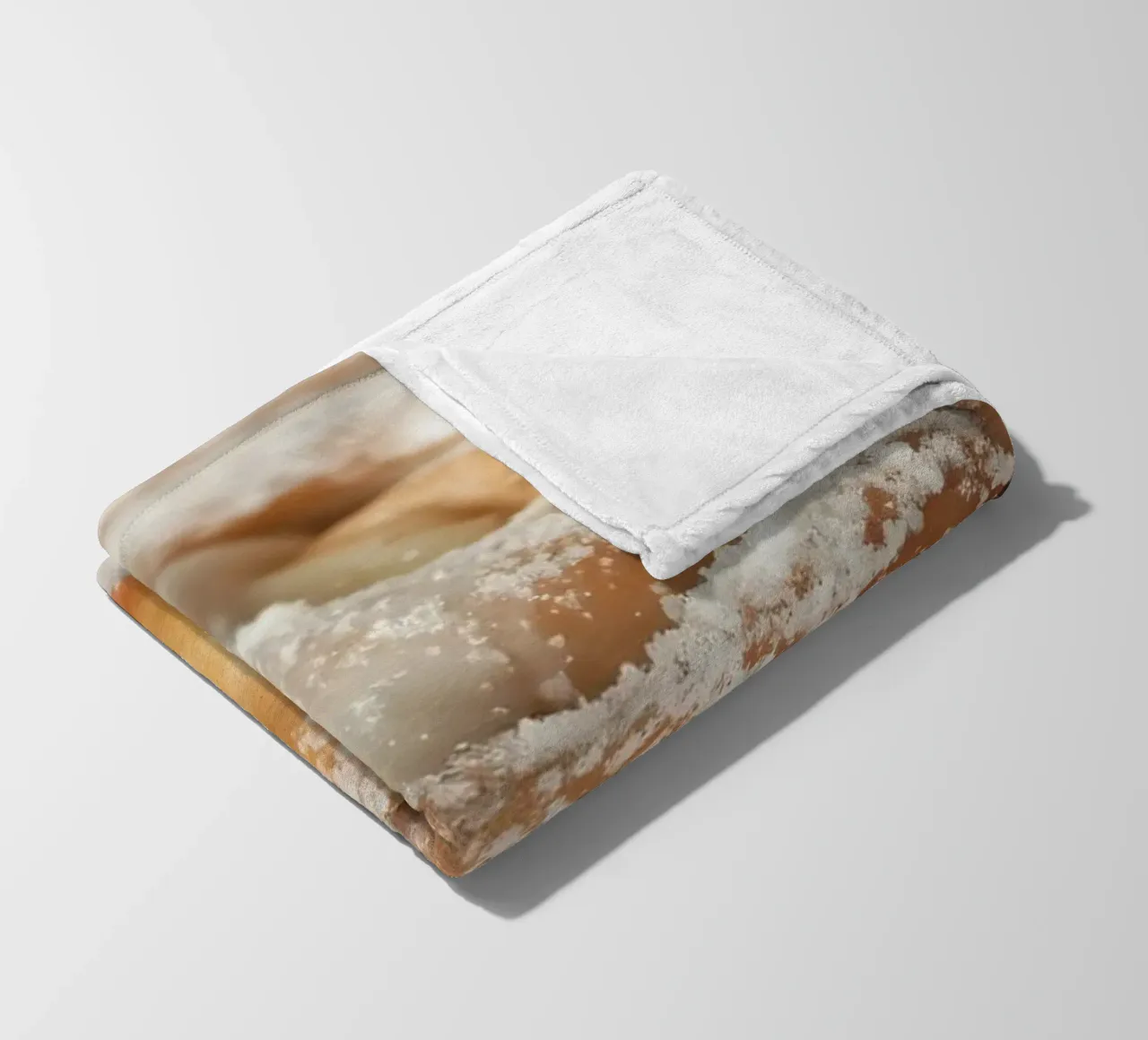 Warm cinnamon roll with cream icing and powdered sugar on a fleece blanket by DesignDoodle