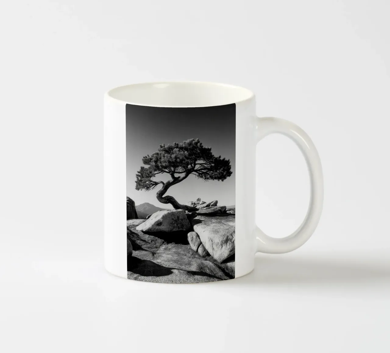 Albero in bianco e nero sulla cima di una montagna tazza in ceramica da Indigo Tides Art