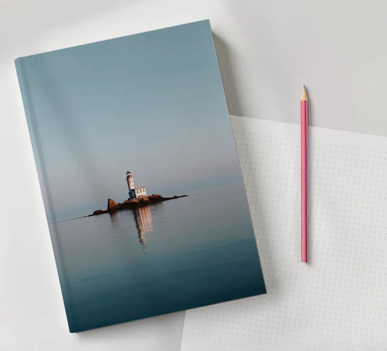 Phare sur un îlot rocheux dans une mer calme carnet de notes de Indigo Tides Art