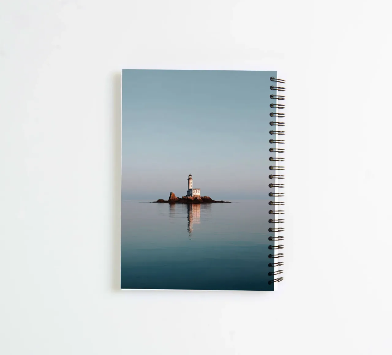Lighthouse on Rocky Islet in Calm Sea spiral notebook by Indigo Tides Art