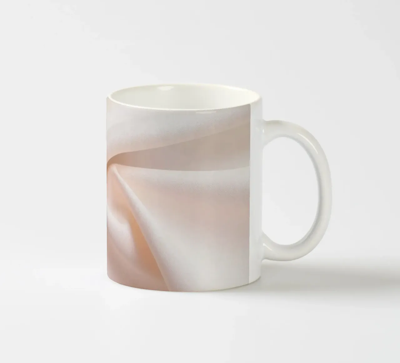 Soft beige fabric draped and folded on a surface ceramic mug by DesignDoodle