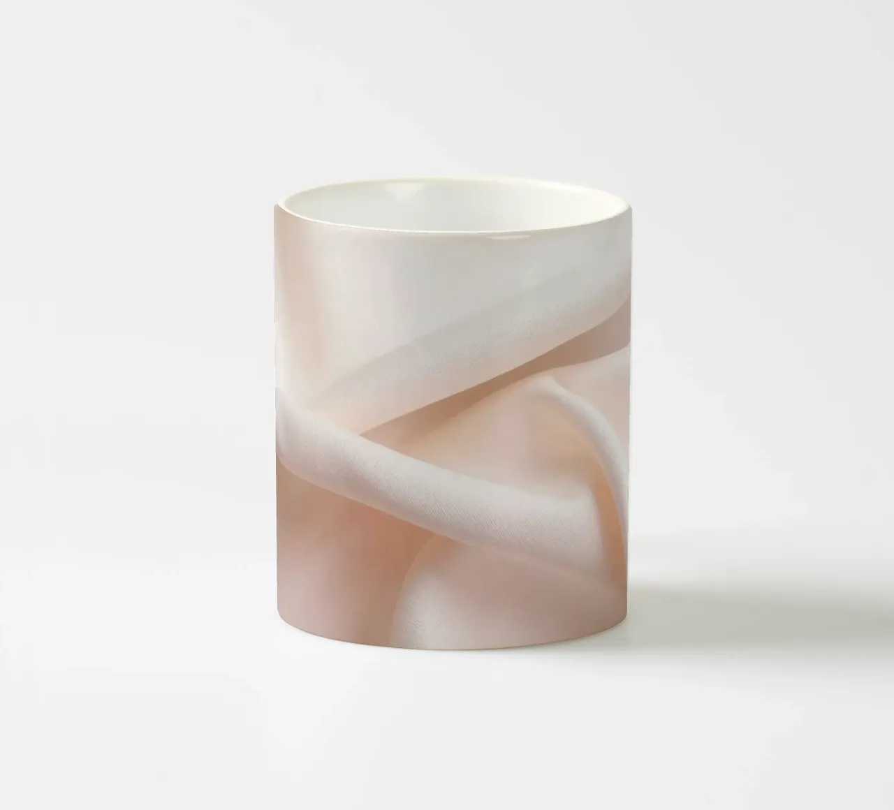 Soft beige fabric draped and folded on a surface ceramic mug by DesignDoodle