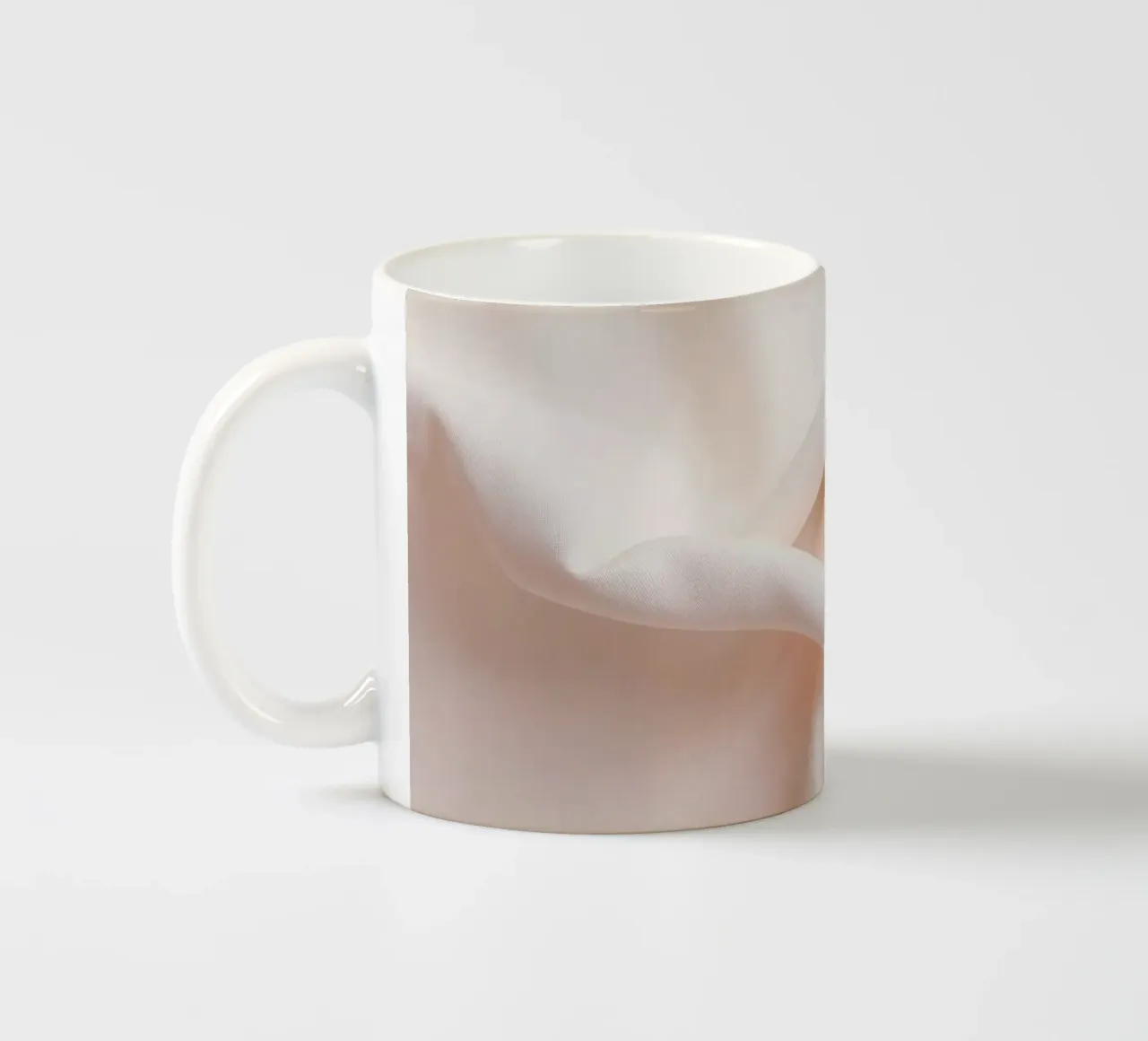 Soft beige fabric draped and folded on a surface ceramic mug by DesignDoodle