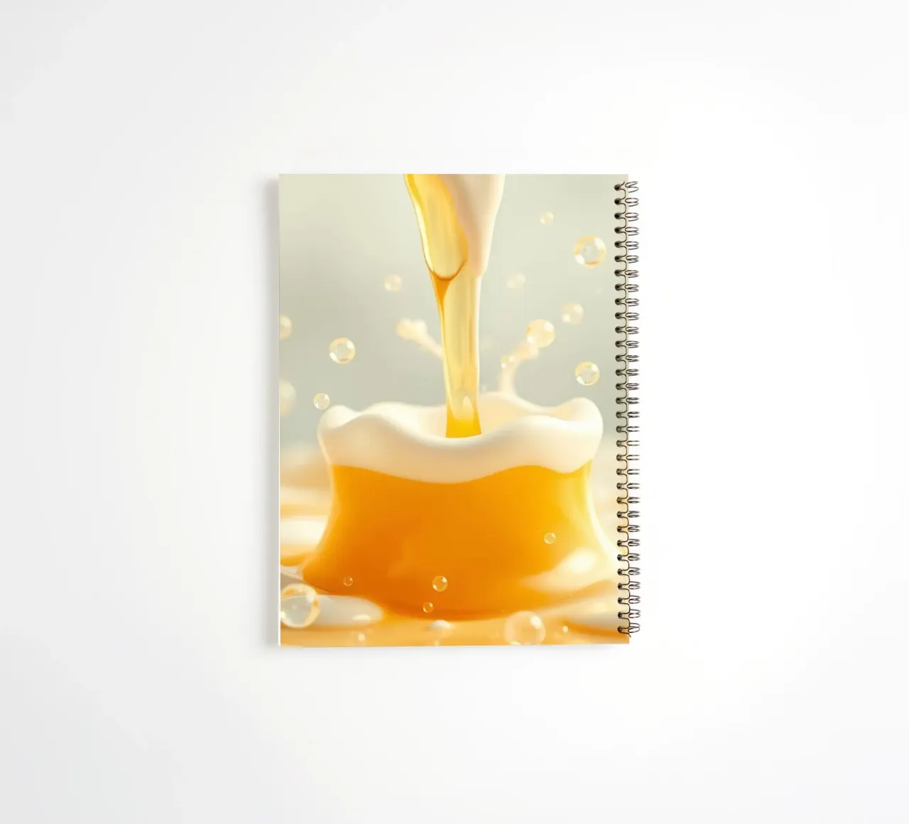 Goldene Flüssigkeit, die sich in einen schaumigen Becher ergießt und die Essenz einfängt Ringbuch von DesignDoodle