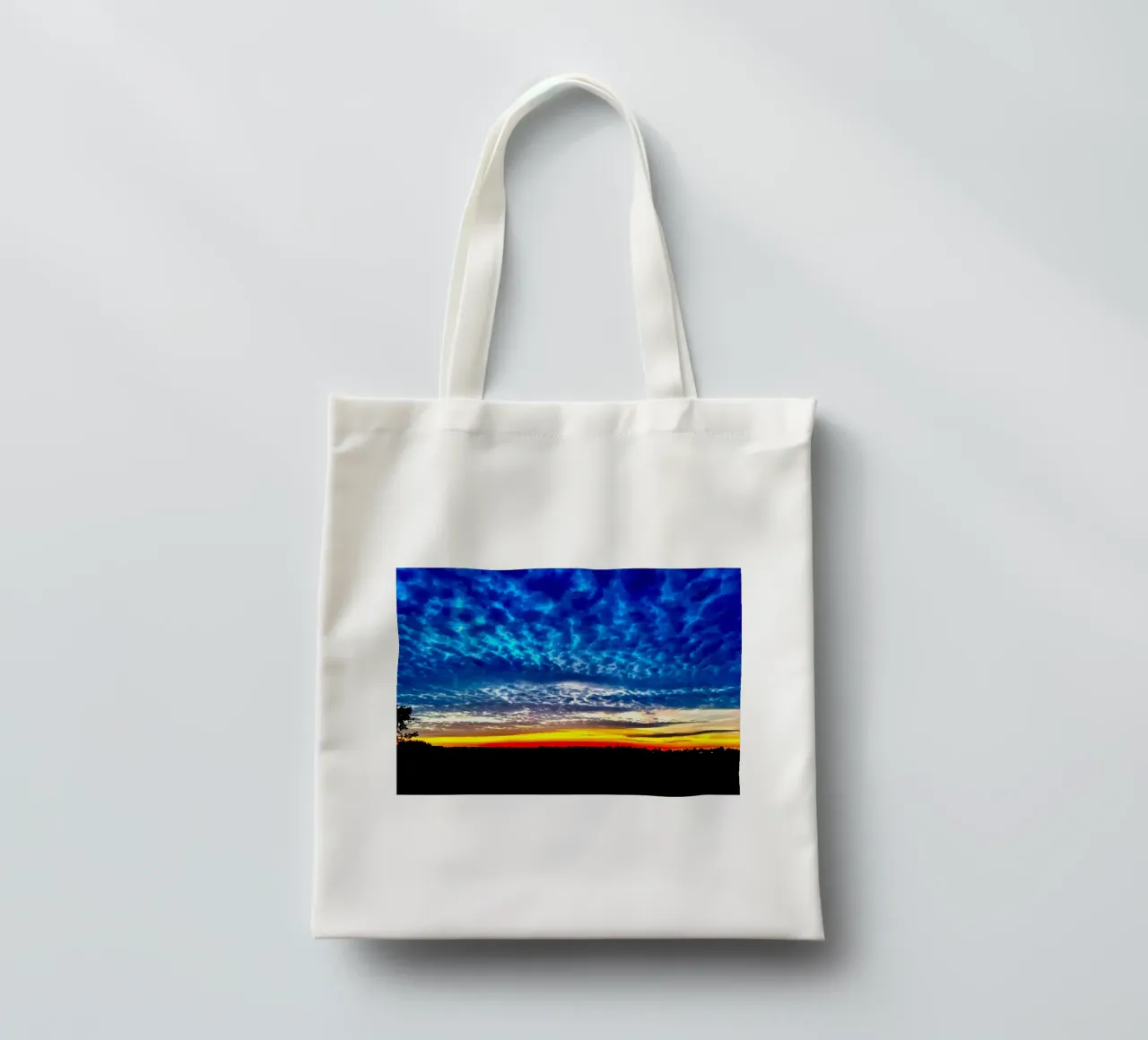 Sunset with dark blue clouds tote bag by RealLifeMoments