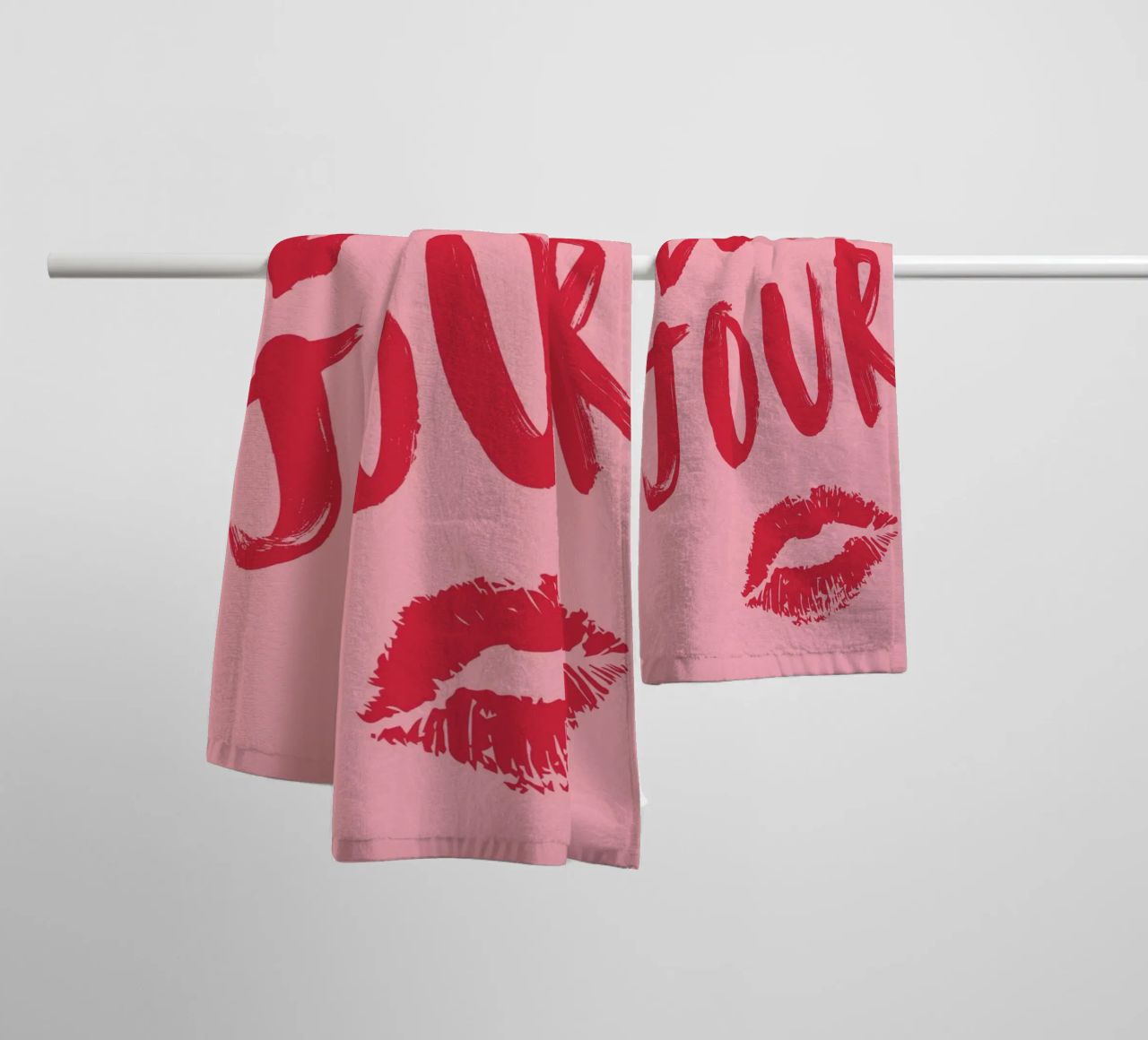 Testo "Bonjour" rosso in grassetto con stampa a labbro su sfondo rosa asciugamano da bagno da pdigitalprints