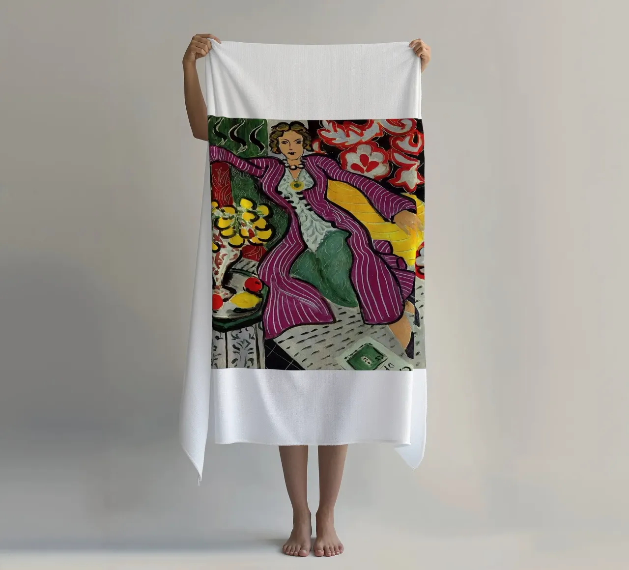 mujer sentada relajadamente con un jarrón de flores sobre la mesa toalla de playa de sazkia art