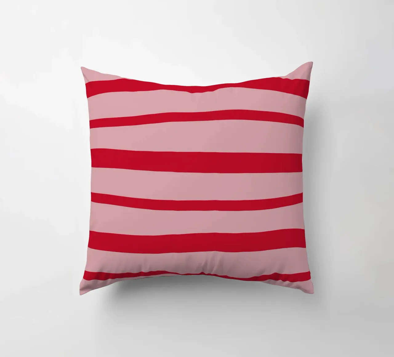 Horizontal hand-painted lines in strawberry red on pink decorative cushion by Stilrausch