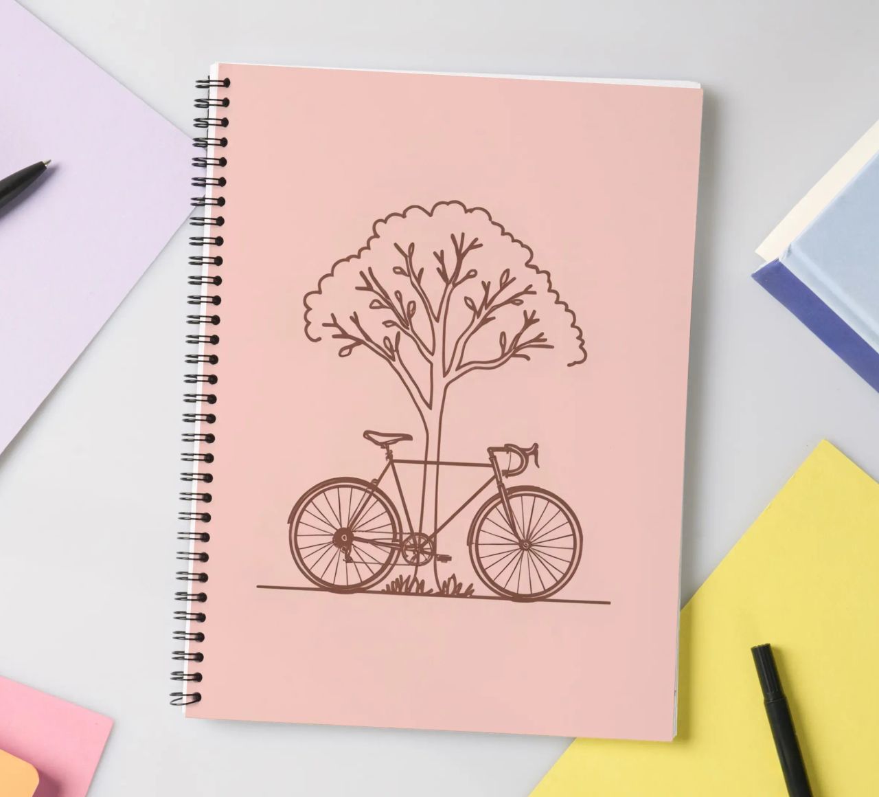 Bicycle leaning against a tree in a park with simple design spiral notebook by DesignDoodle