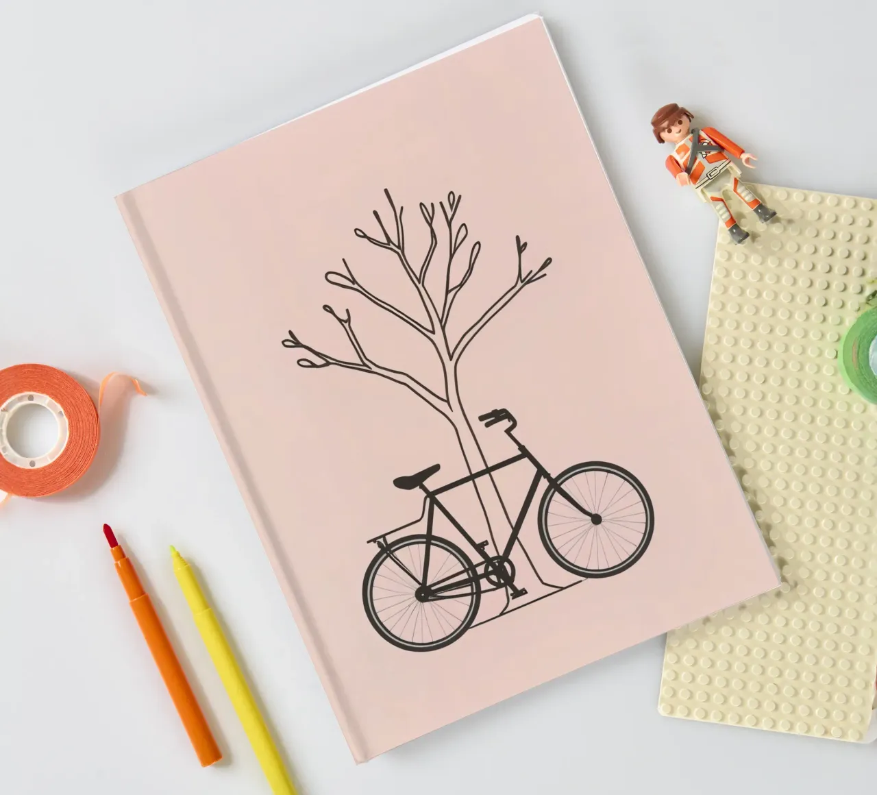 Bicyclette adossée à un arbre dénudé sur un arrière-plan discret carnet de notes de DesignDoodle