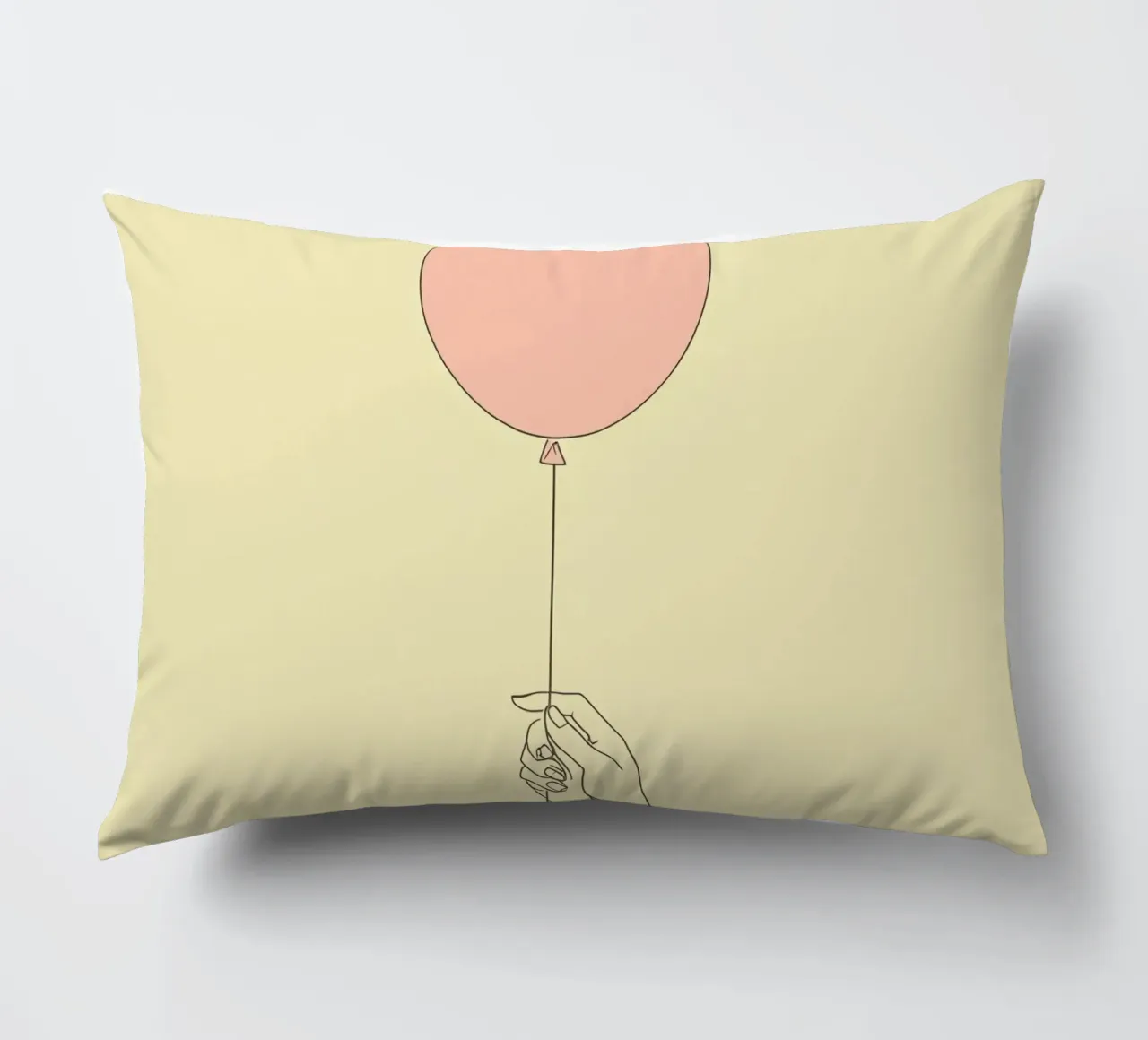 Mano che tiene un palloncino rosa su un'opera d'arte giallo tenue cuscino da DesignDoodle