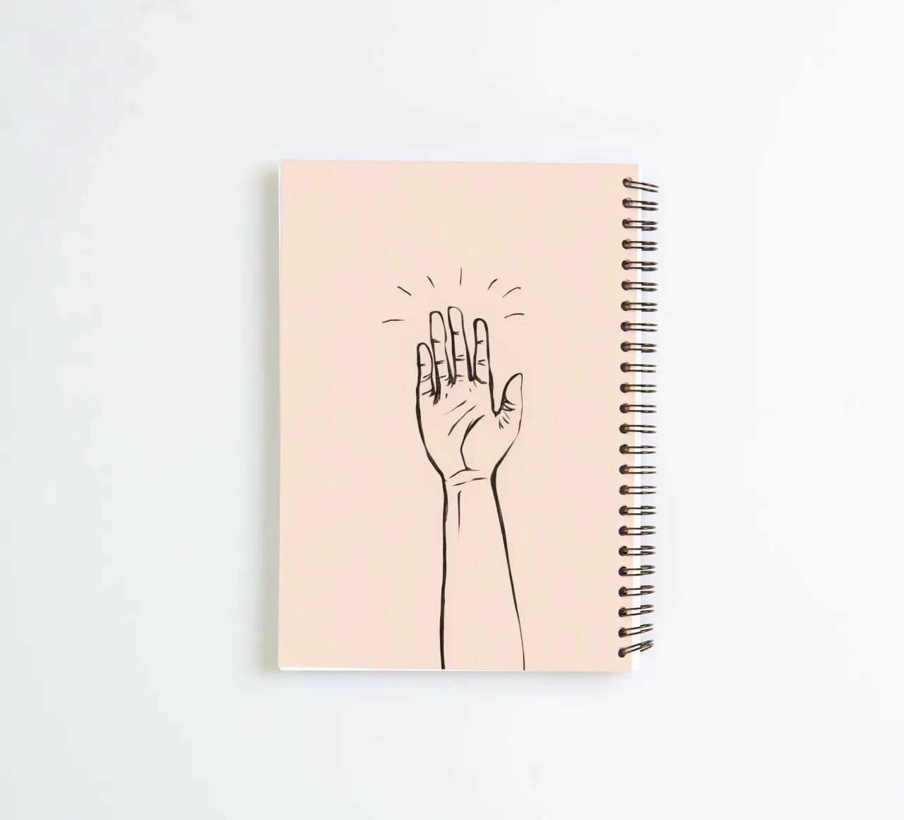 Hand raised in greeting gesture against a simple pastel art spiral notebook by DesignDoodle