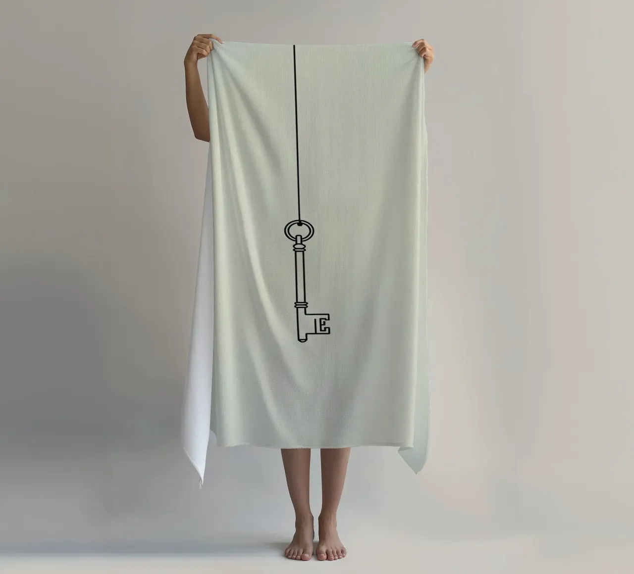 Key hanging from a string against a light backdrop beach towel by DesignDoodle