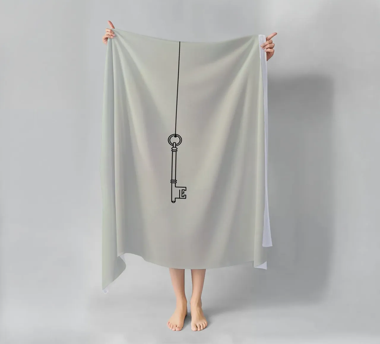 Key hanging from a string against a light backdrop beach towel by DesignDoodle