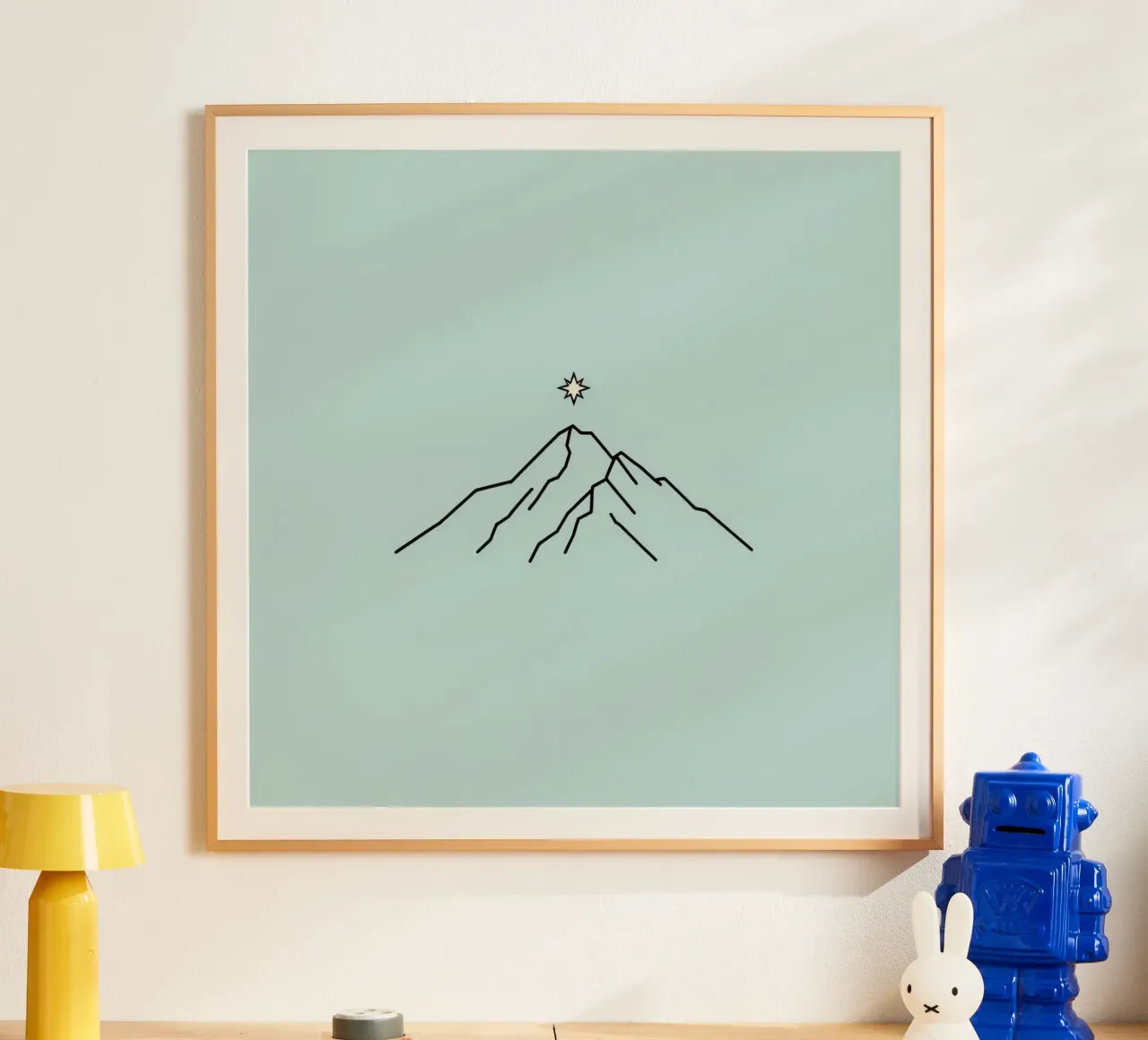 Sagoma di montagna con stella sovrastante su sfondo azzurro poster con telaio in legno da DesignDoodle