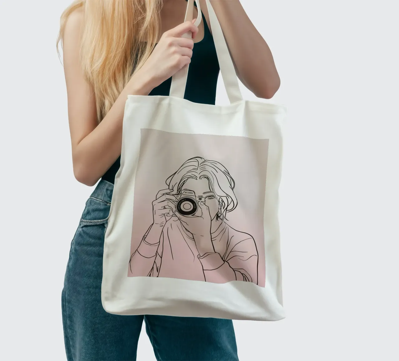 Young woman holding a camera and capturing memories tote bag by DesignDoodle