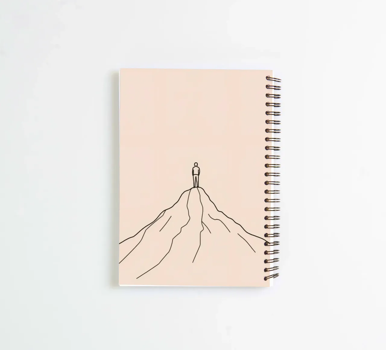Lonely person standing atop a mountain peak against a simple spiral notebook by DesignDoodle