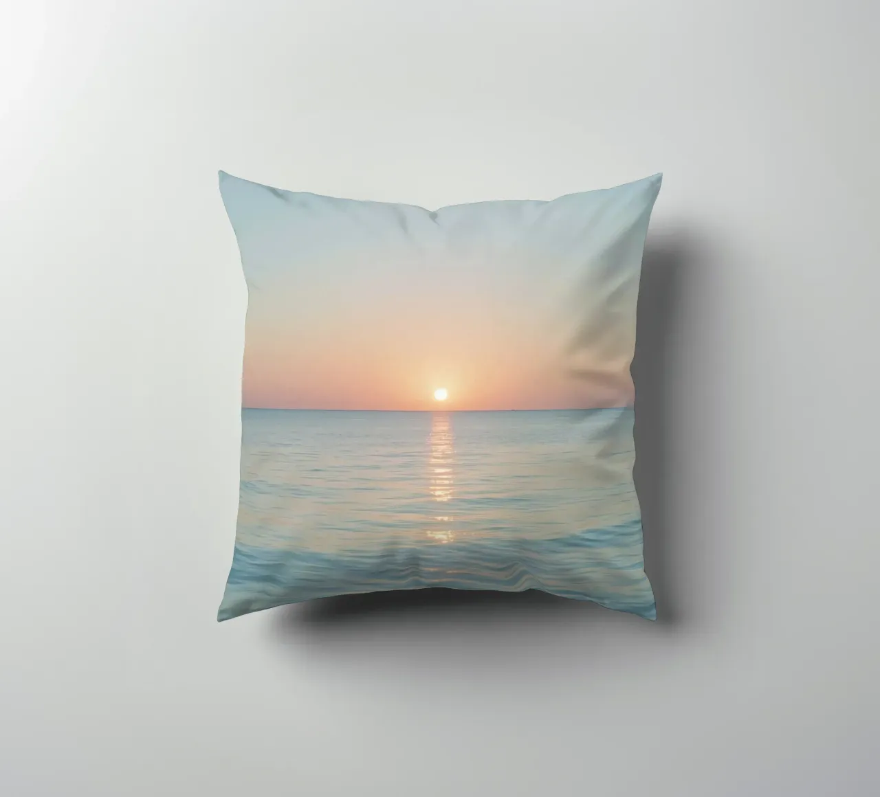 Sunset over calm ocean waters with pastel hues reflecting decorative cushion by DesignDoodle