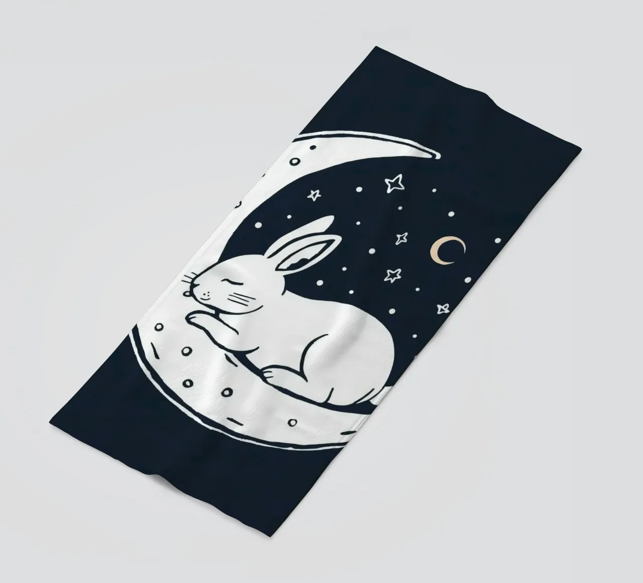 Lapin endormi reposant sur un croissant de lune entouré d'étoiles serviette de plage de DesignDoodle