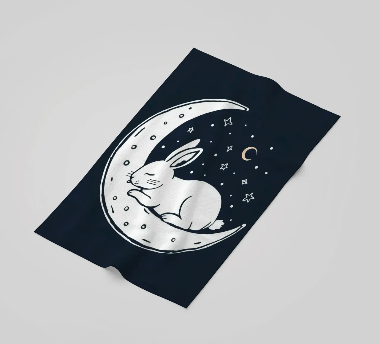 Lapin endormi reposant sur un croissant de lune entouré d'étoiles serviette de plage de DesignDoodle