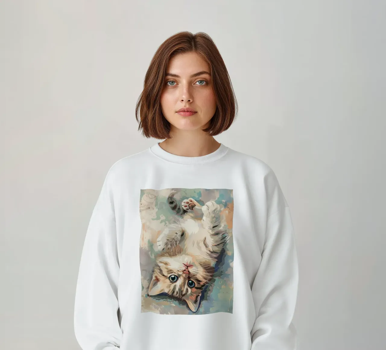 fluffy kitten with bright eyes, playfully lying on its back sweatshirt by DesignDoodle
