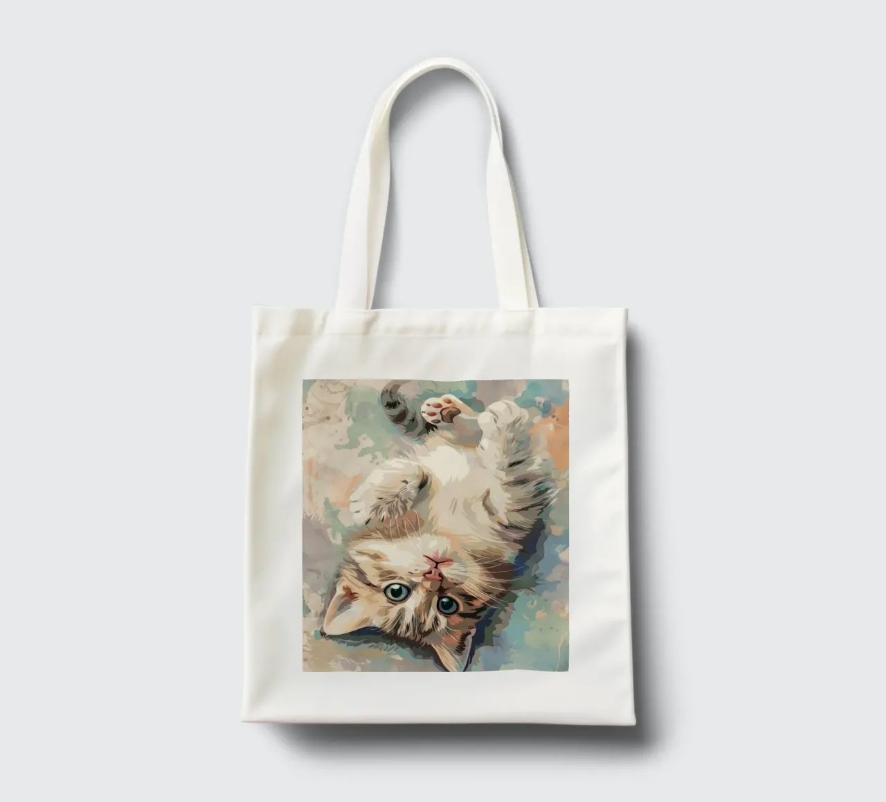 fluffy kitten with bright eyes, playfully lying on its back tote bag by DesignDoodle