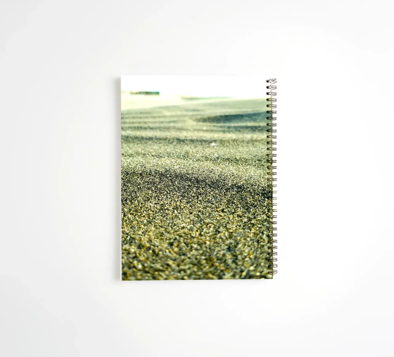 desert with green spiral notebook by life of sands
