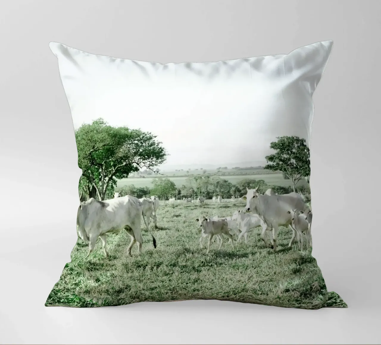 Mucche bianche in un campo verde cuscino da KISSA STUDIO