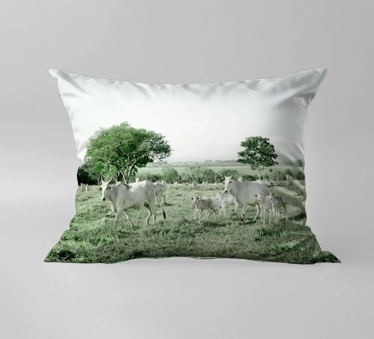 Mucche bianche in un campo verde cuscino da KISSA STUDIO