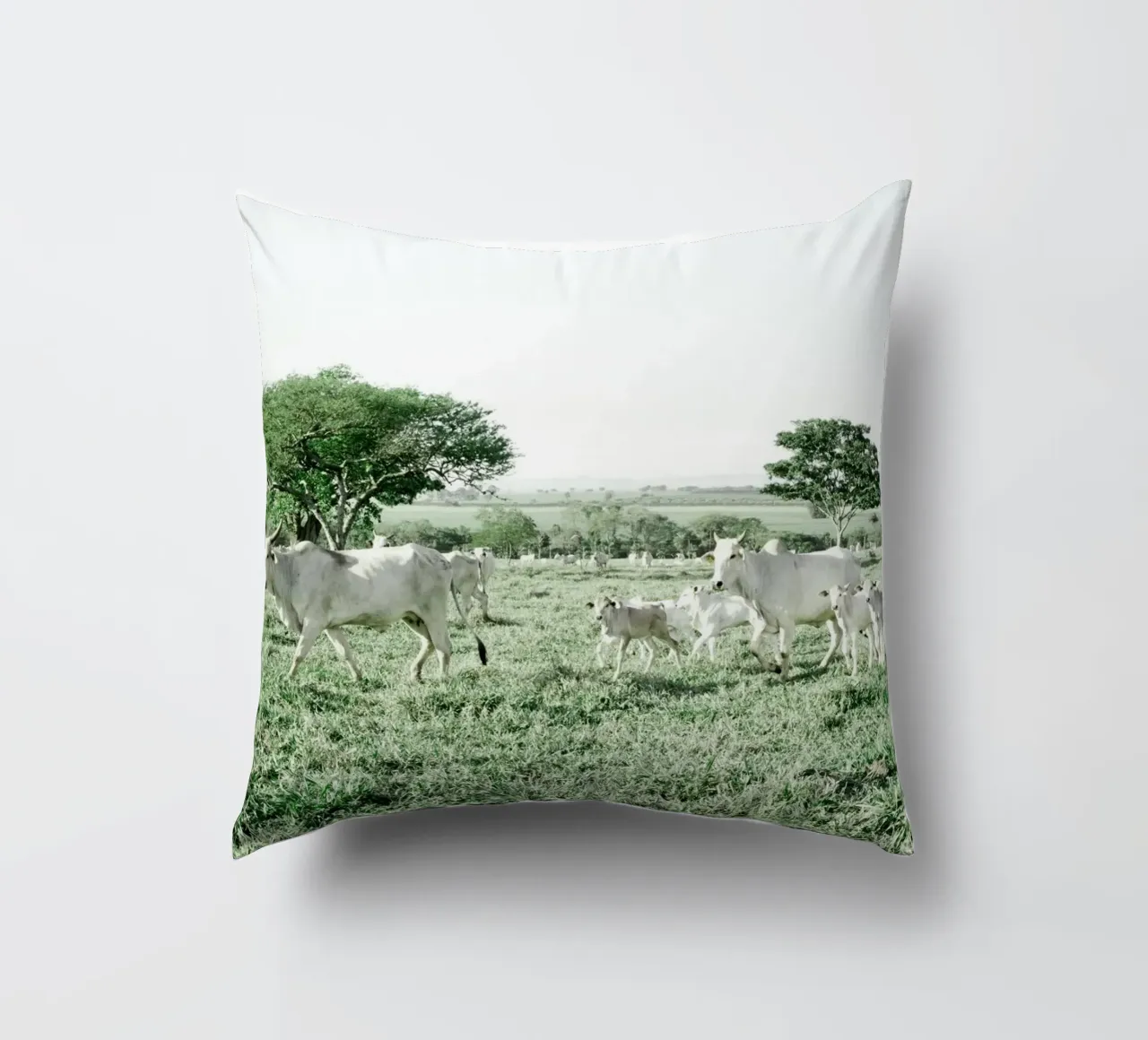 Mucche bianche in un campo verde cuscino da KISSA STUDIO
