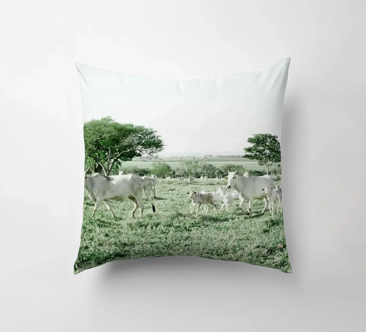 Mucche bianche in un campo verde cuscino da KISSA STUDIO