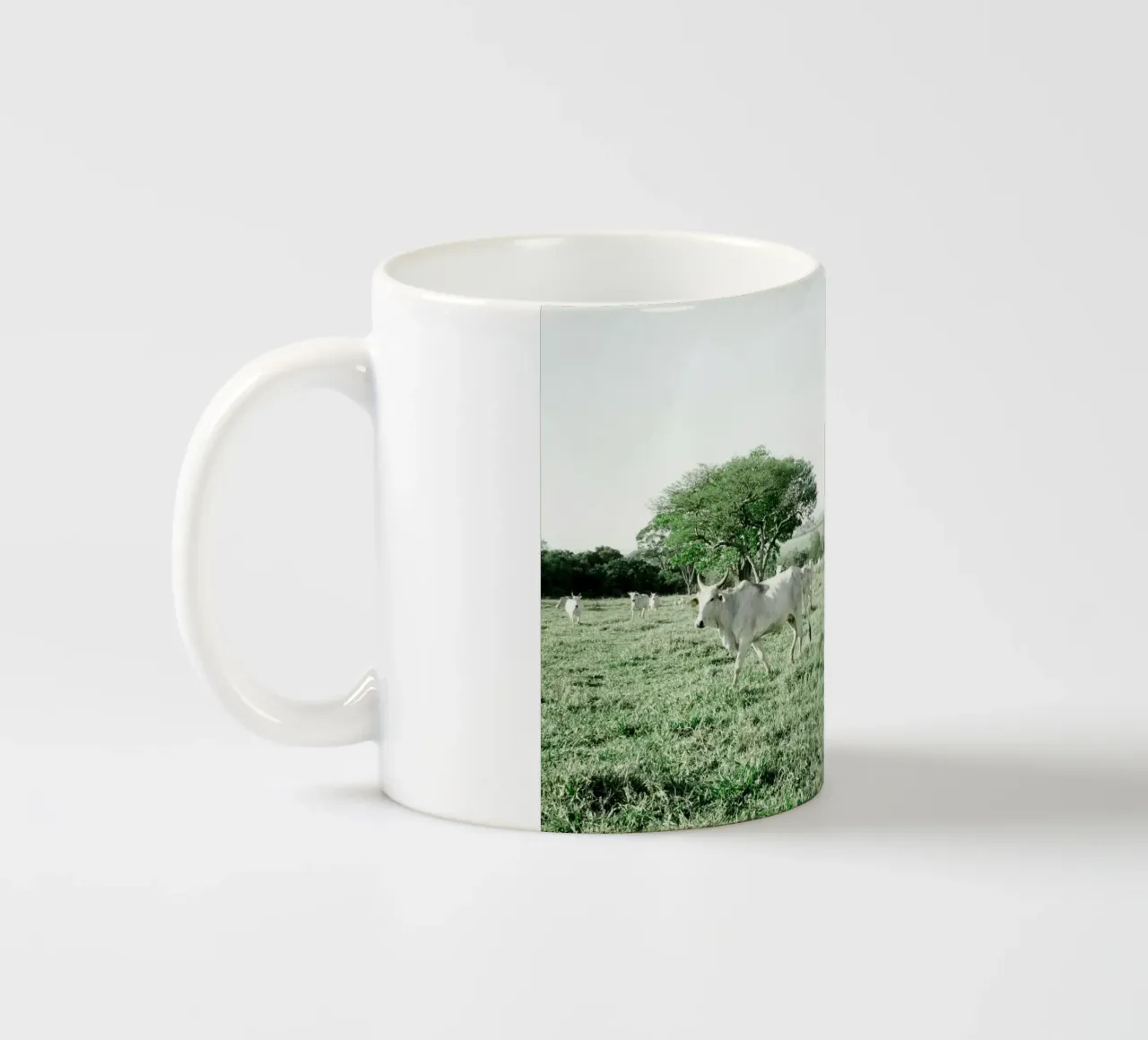 Mucche bianche in un campo verde tazza in ceramica da KISSA STUDIO