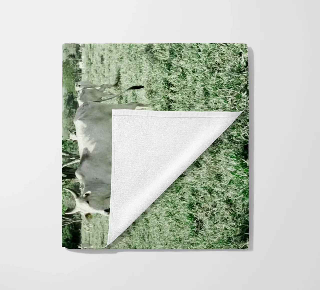 Mucche bianche in un campo verde telo mare da KISSA STUDIO