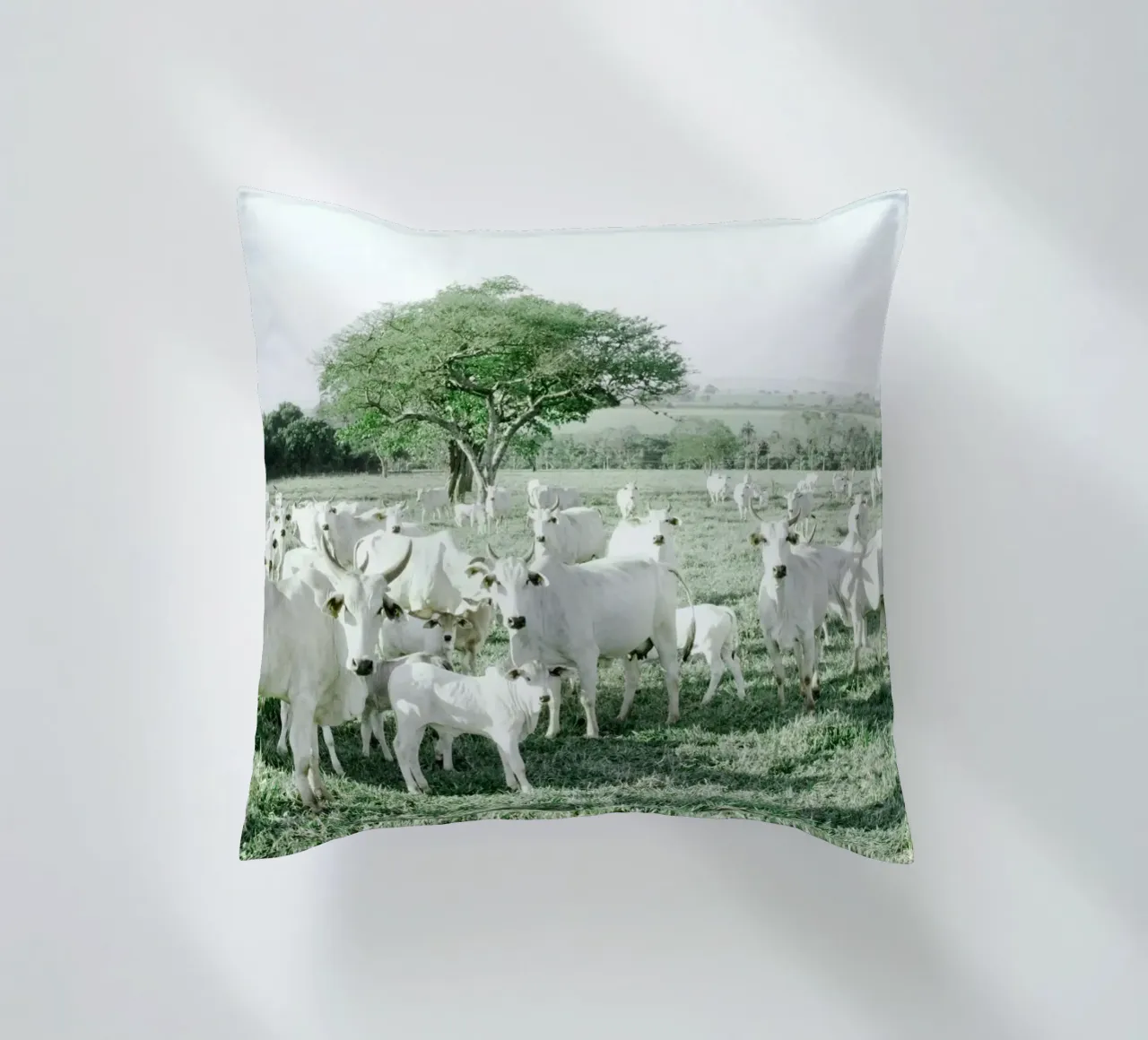 Mucche bianche in un campo verde cuscino da KISSA STUDIO