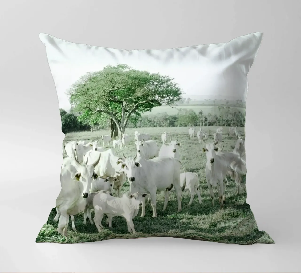 Mucche bianche in un campo verde cuscino da KISSA STUDIO